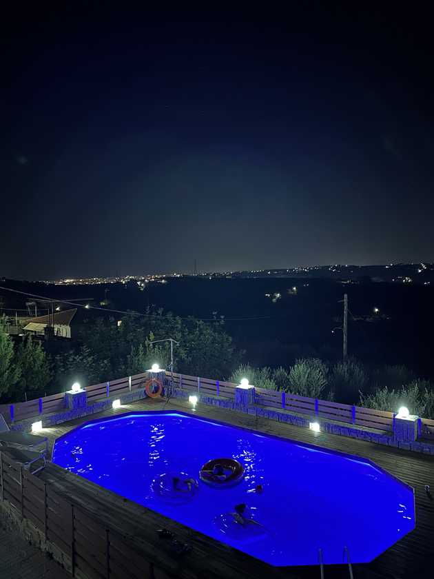 The view from the villa balcony. A pool and Heraklion at night.